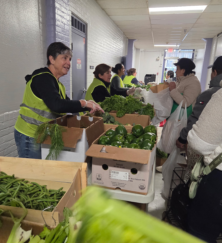 Workers in a hallway distributing fresh green vegetables