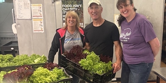3 people with baskets of leafy greens