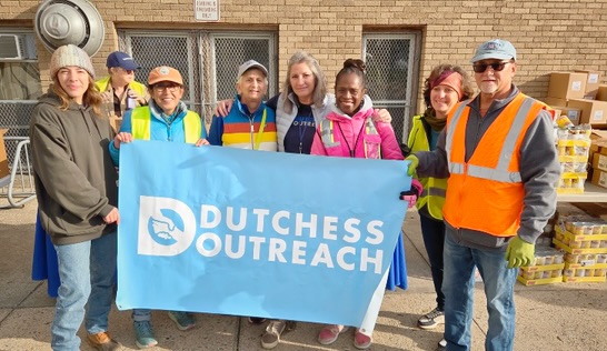 workers holding Dutchess Outreach Banner