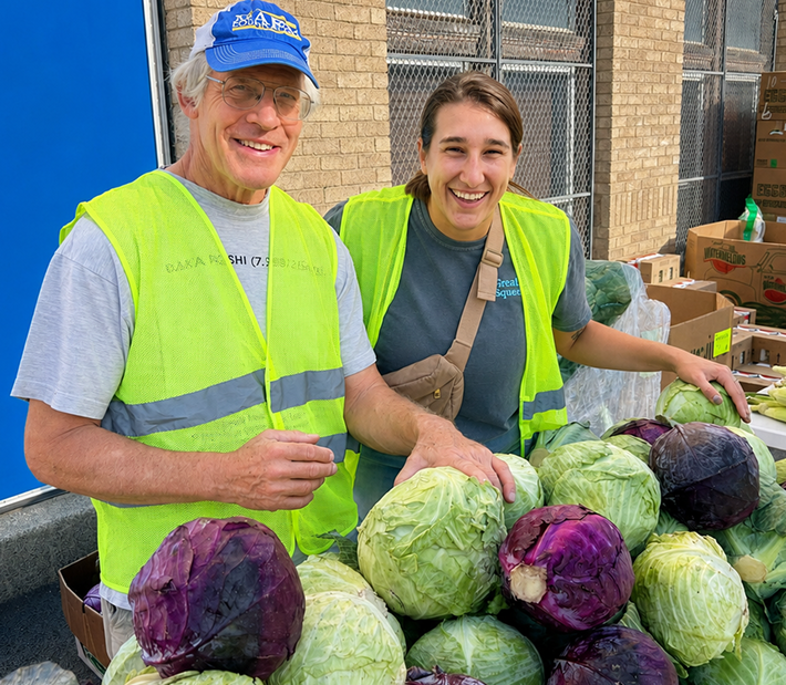 2 Workers in green vests and a lot of cabbages